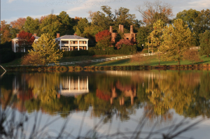 Looking over the lake at Barboursville Vineyards to see the 1804 Inn, the Barboursville Ruins and colorful fall foliage reflected on the water.