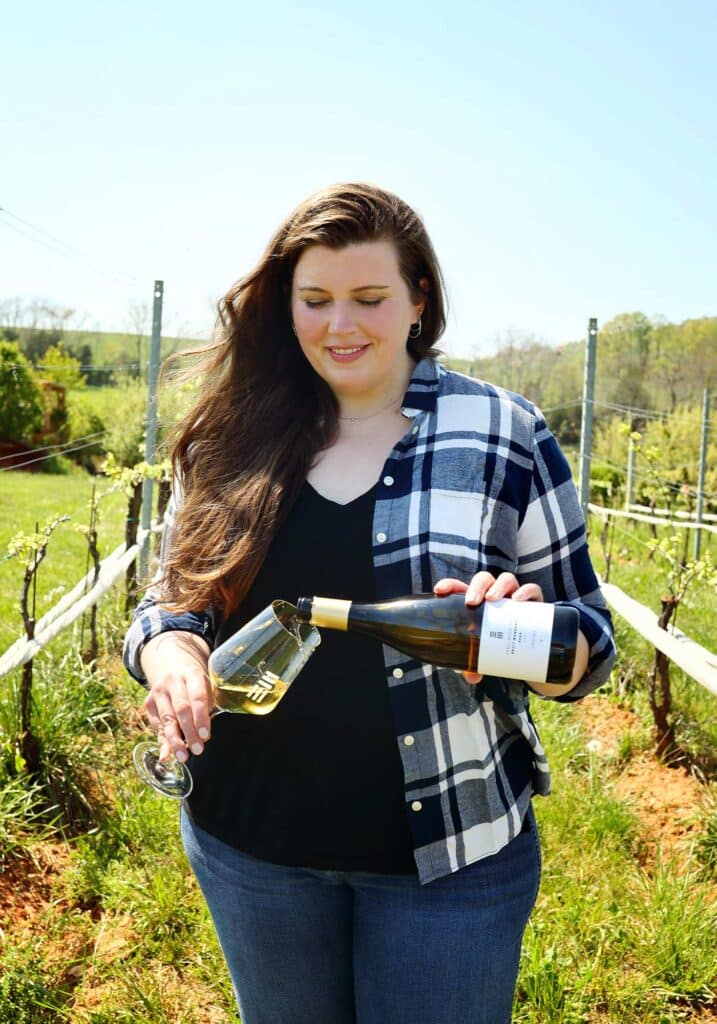 maya hood white early mountain vineyard female winemaker pouring wine in vineyard