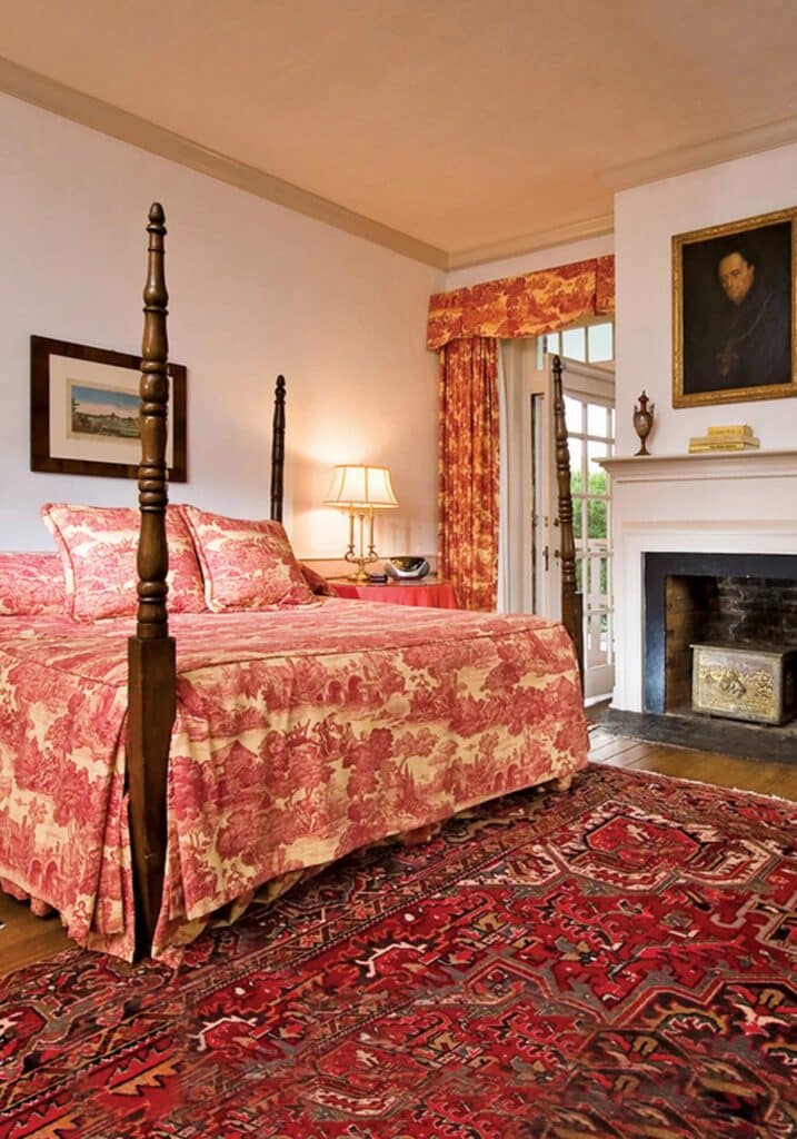 A room at the historic 1804 inn at Barboursville Vineyards with 4-poster bed and red toile linens.