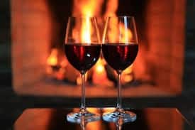 red wines by a fireplace