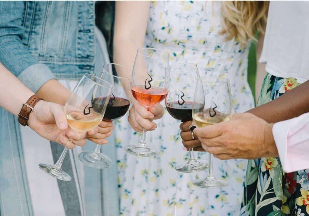 Photo of several hands with wine glasses together