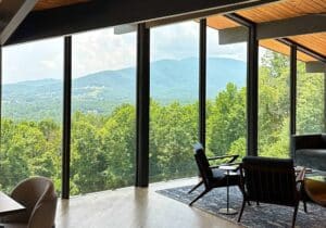 Photo of a room with large glass windows with mountain views