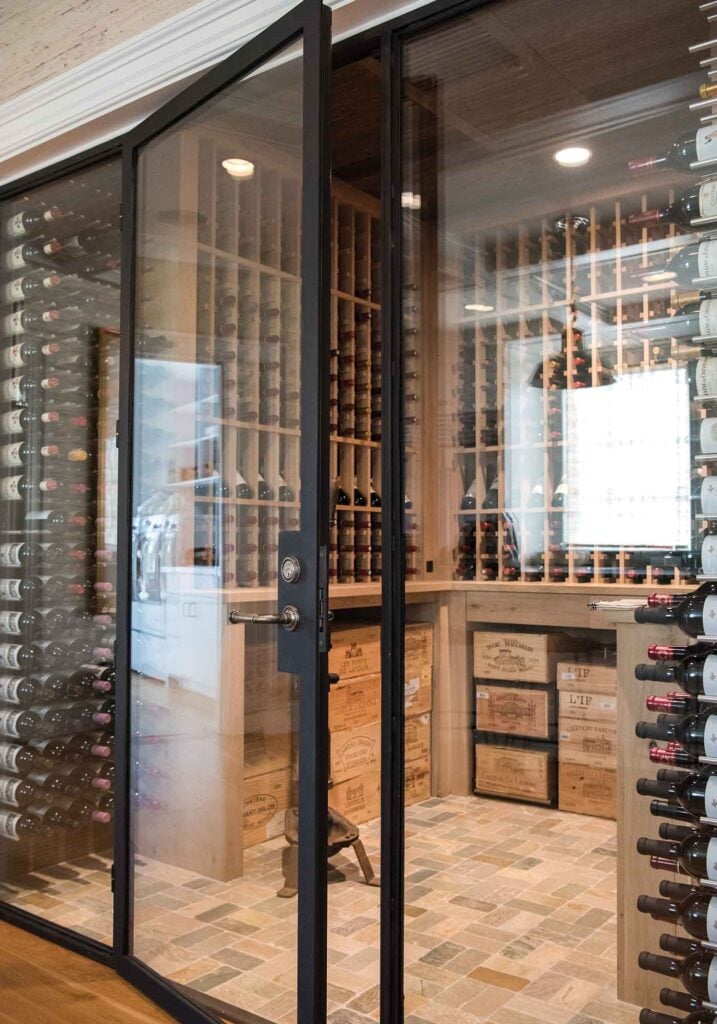 Glass walls and doors on wine cellar with floor to ceiling bottle storage for your wine collection.