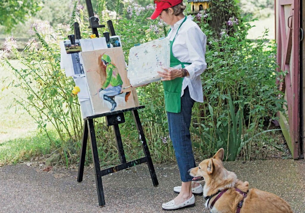 artist Martha Strawther painting with dog