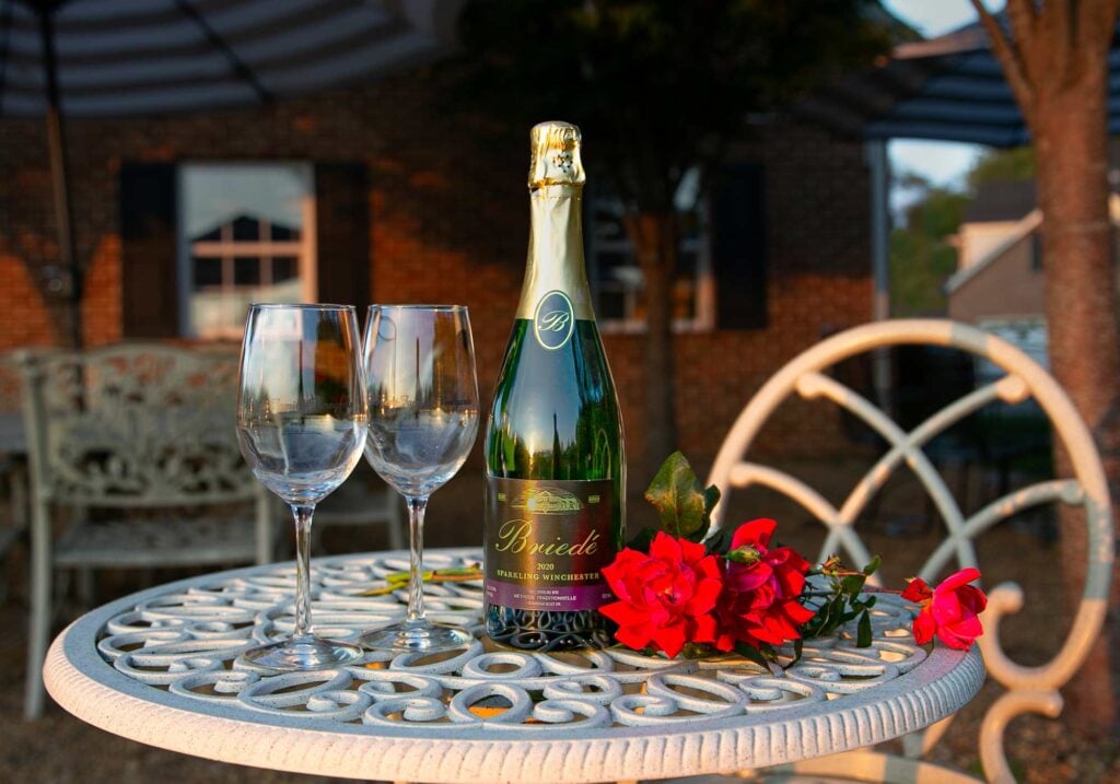 Photo of bottle of wine and glasses on patio table at Briede Family Vineyards