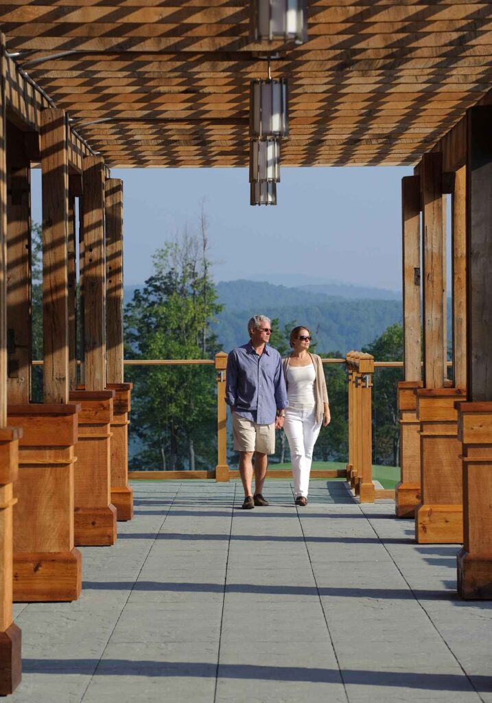 Primland resort couple walking with mountain views behind