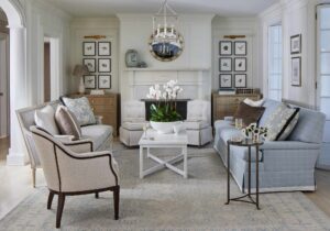 Casey Sanford designed home with elegant French touches. Round gold mirror above white mantel, collage of nature art