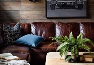 Cozy study with leather sofa and vintage auto art designed by Casey Sanford ofVirginia