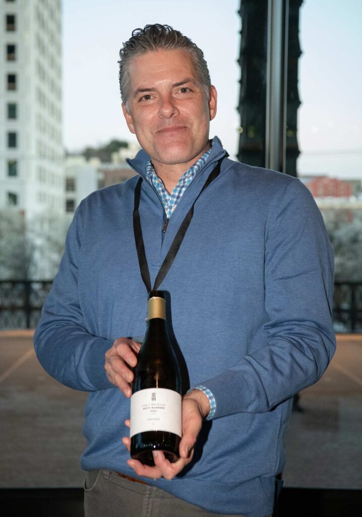 Early Mountain Vineyards general manager Dave Kostelnik holding their gold medal bottle at the Virginai Governor's Cup Gala 2024