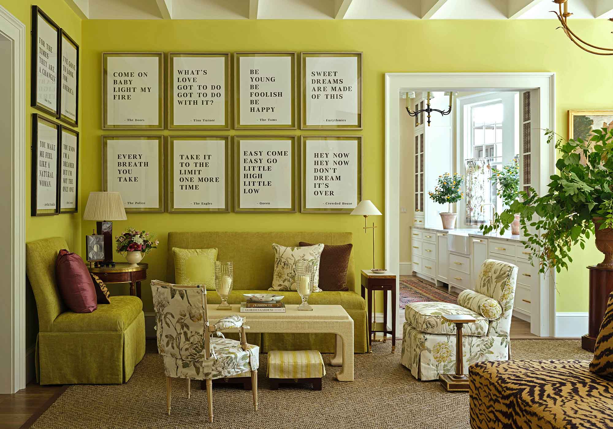 Vibrant chartreuse living room in the 2025 Southern Living Idea House designed by Charlotte Moss, with floral Schumacher draperies, tiger-striped ottoman, and large picture windows.