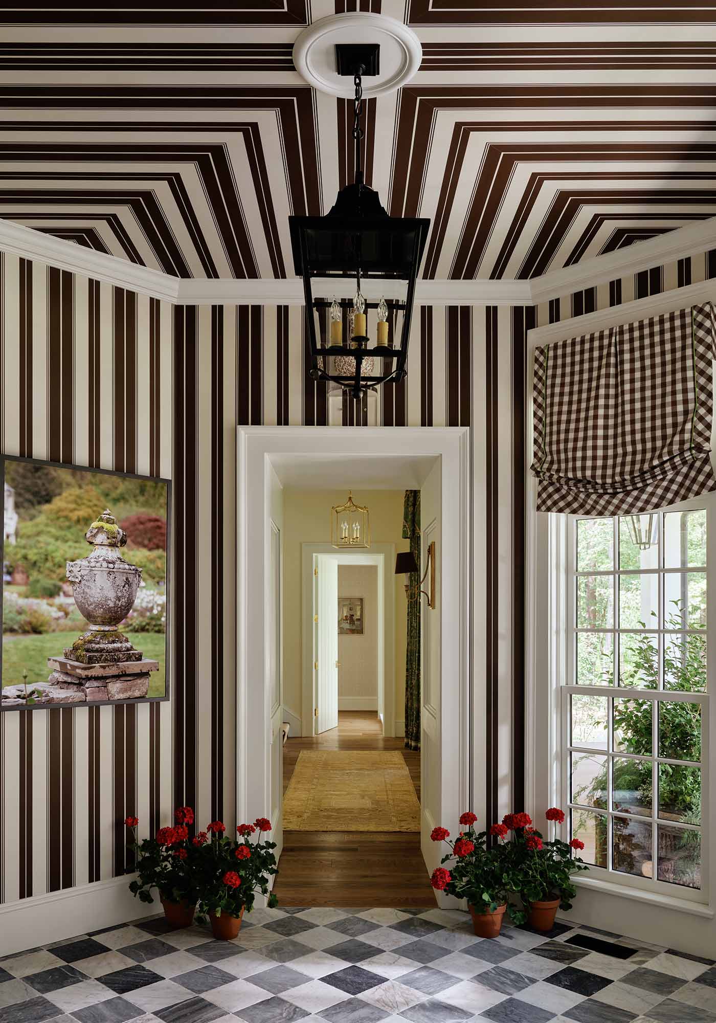 Octagonal entry foyer of the 2025 Southern Living Idea House by Charlotte Moss, featuring striped Norfolk wallpaper, checkerboard Spanish marble floors, and a Carrington lantern.