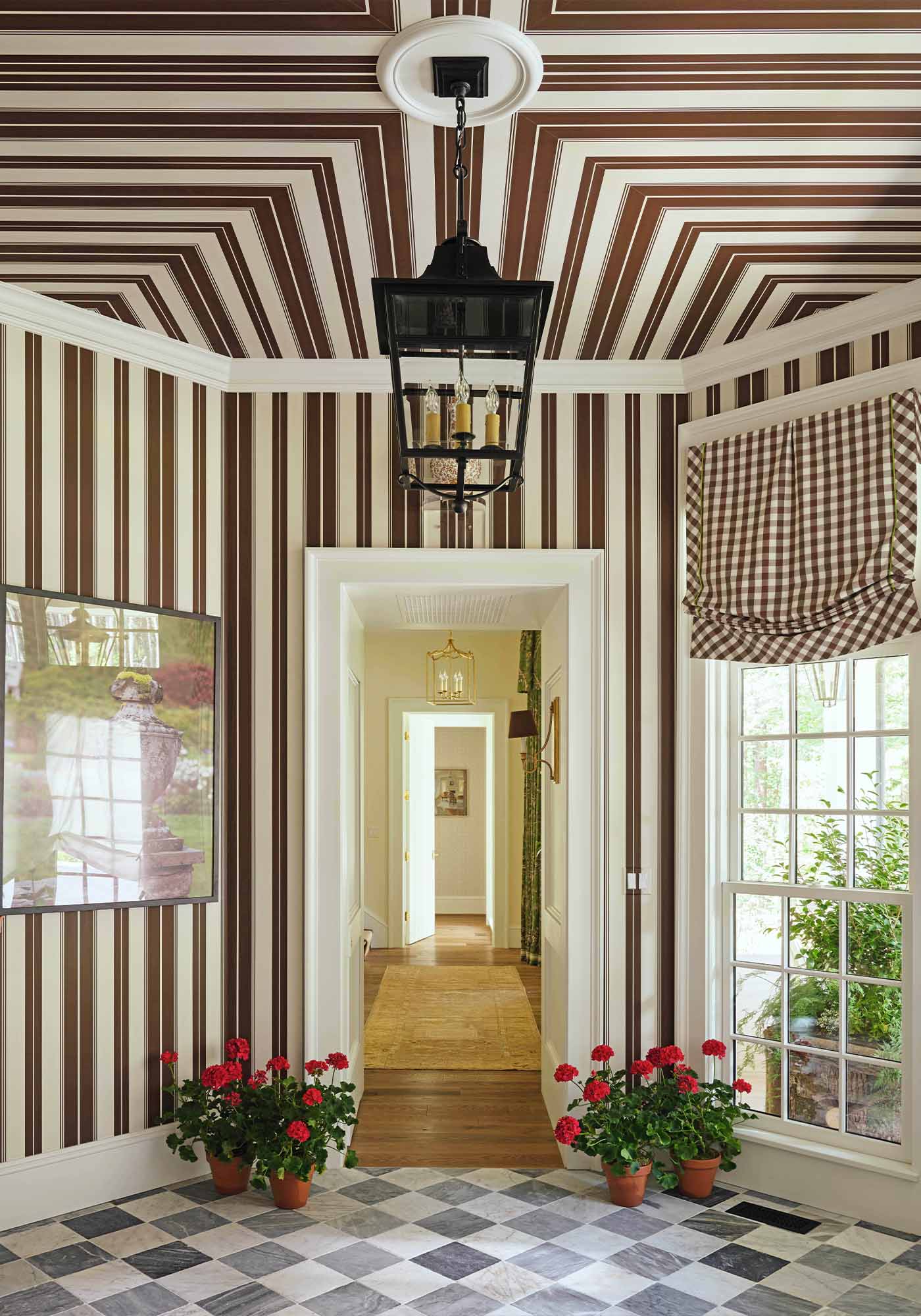 Octagonal entry foyer of the 2025 Southern Living Idea House by Charlotte Moss, featuring striped Norfolk wallpaper, checkerboard Spanish marble floors, and a Carrington lantern.