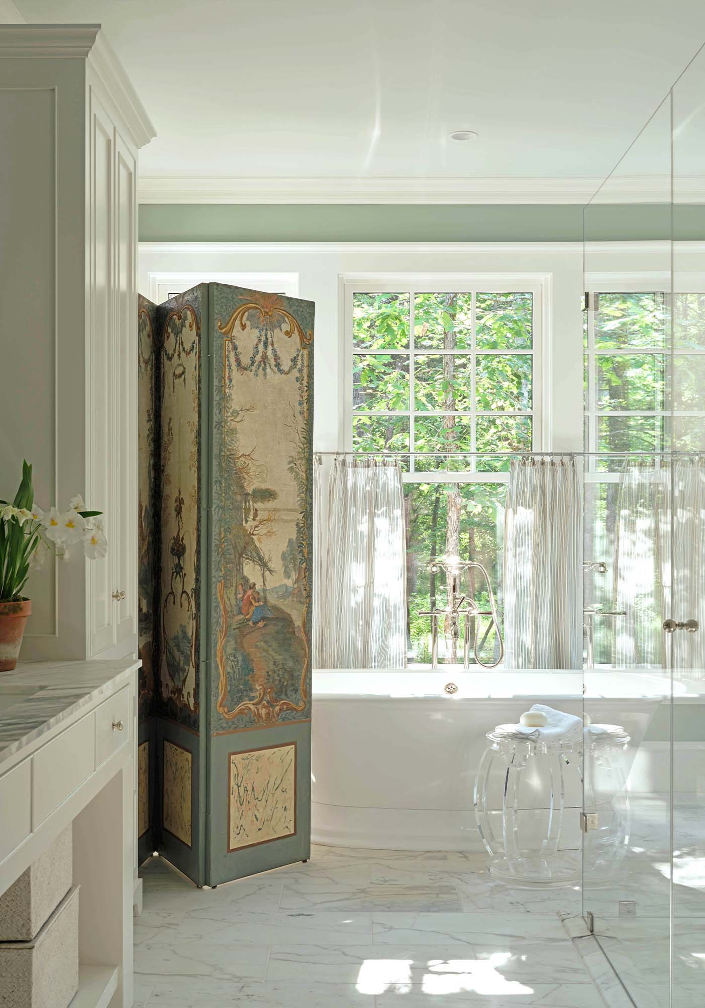Master bathroom in the 2025 Southern Living Idea House by Charlotte Moss, featuring a freestanding bathtub, vintage French screen, double vanity, and sophisticated neutral finishes.