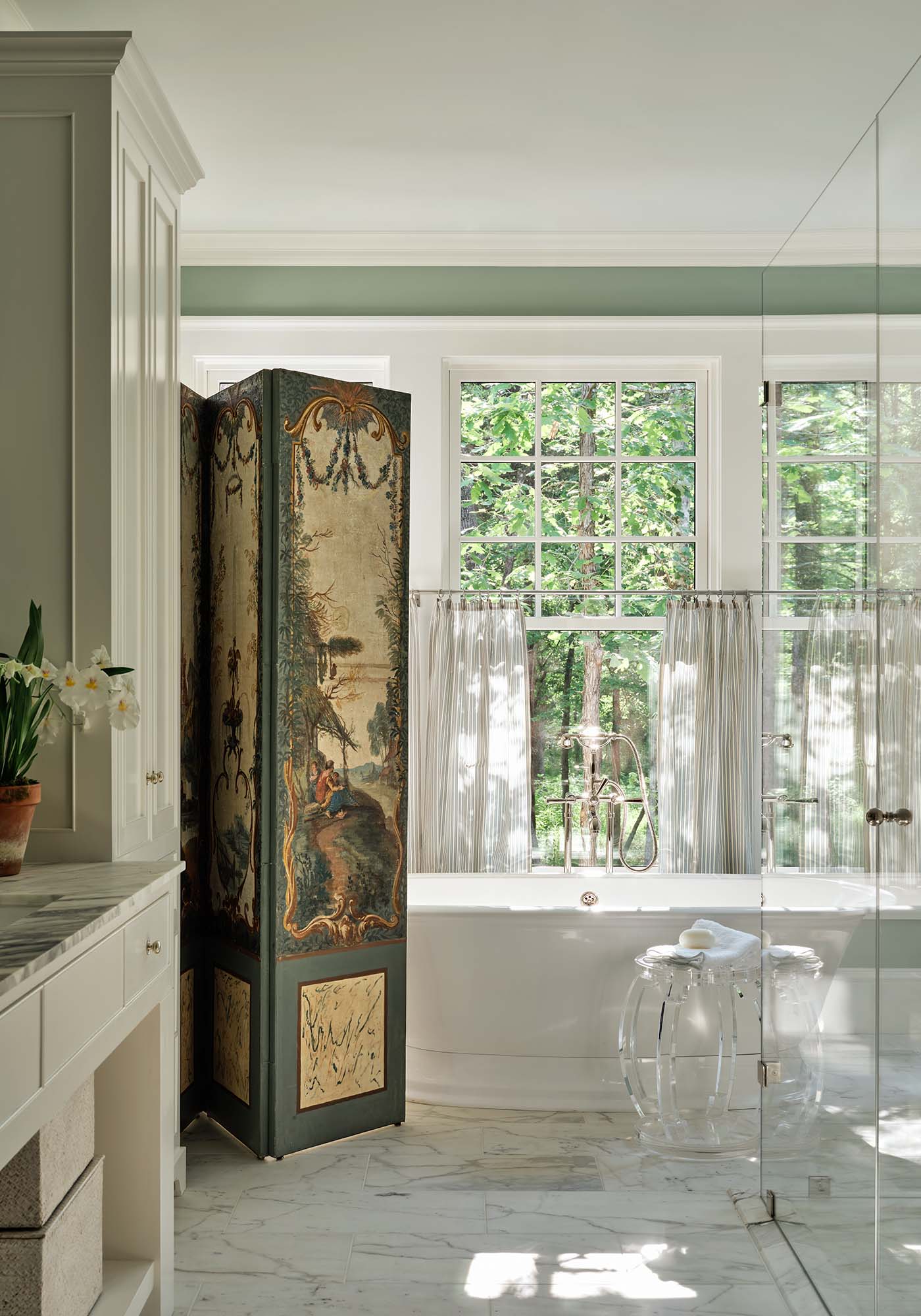 Master bathroom in the 2025 Southern Living Idea House by Charlotte Moss, featuring a freestanding bathtub, vintage French screen, double vanity, and sophisticated neutral finishes.