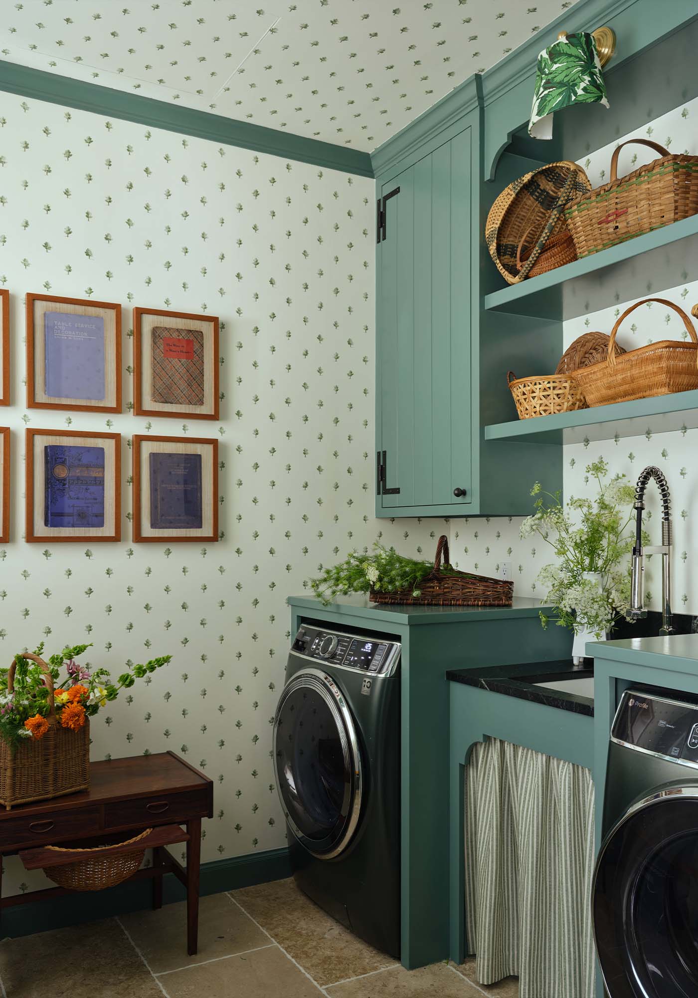 Laundry room in the 2025 Southern Living Idea House designed by Charlotte Moss, featuring botanical tree-print wallpaper and GE Profile appliances.