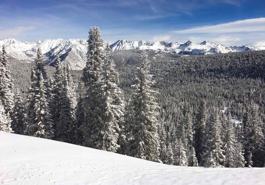 Scenic view of snow-covered Rocky Mountains and pine-covered slopes in Vail, Colorado, during winter.