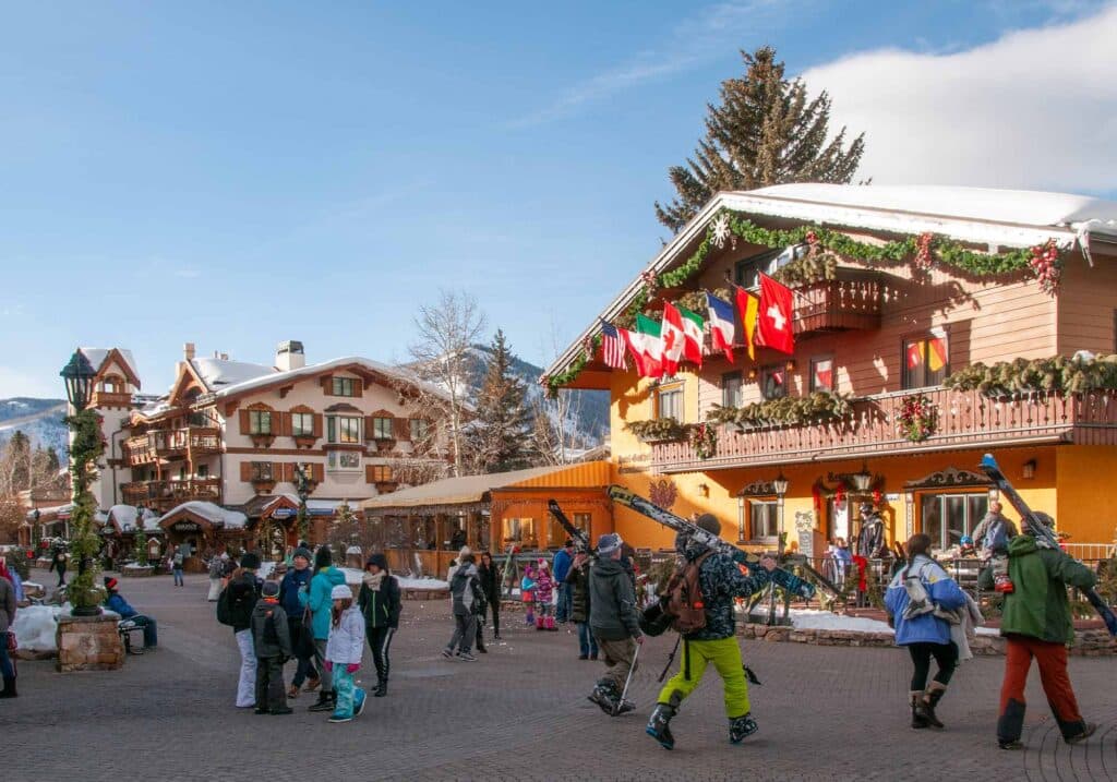 Vail Village street covered in snow, with pedestrians walking safely on heated walkways in ski boots.
