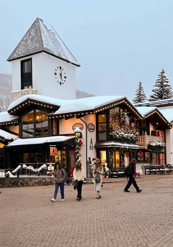 Visitors enjoying a wintery Vail Village scene with snow-covered buildings and dry walkways.