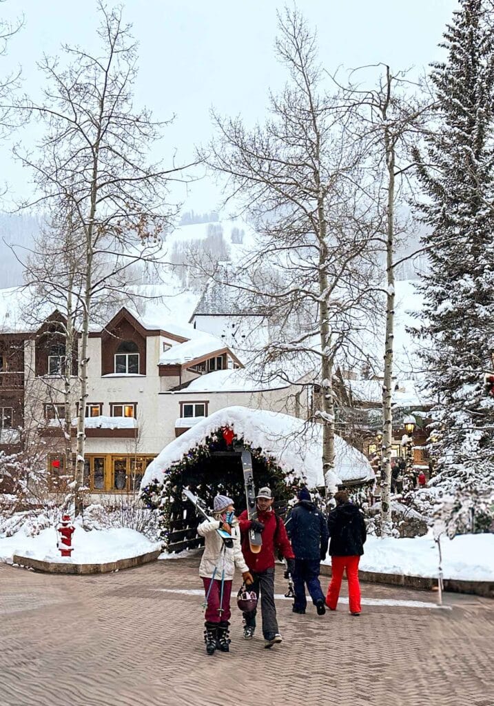 Visitors enjoying a wintery Vail Village scene with snow-covered buildings and dry walkways.