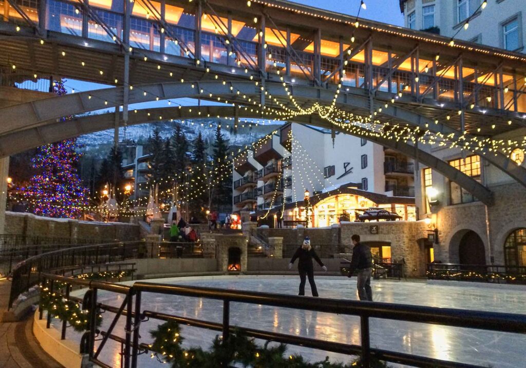 Skaters enjoying a snowy winter day at an ice rink in Vail, Colorado.