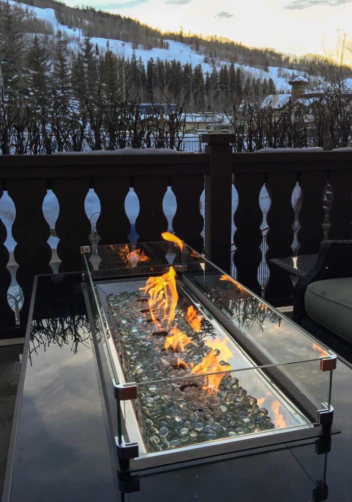 Marble fire table on a Vail, Colorado balcony with snowy mountain views in the background.