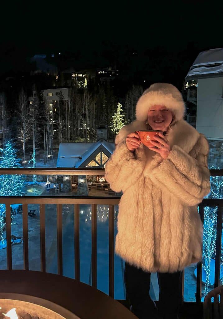 Guests enjoying après-ski drinks and conversation beside a roaring fireplace at Vail’s Remedy Bar.