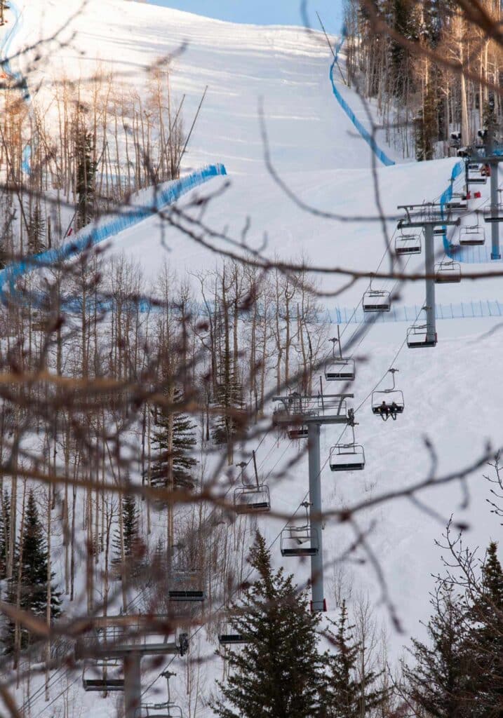 Ski gondola ascending a snow-covered mountain at Vail Resort, Colorado, with alpine scenery in the background.