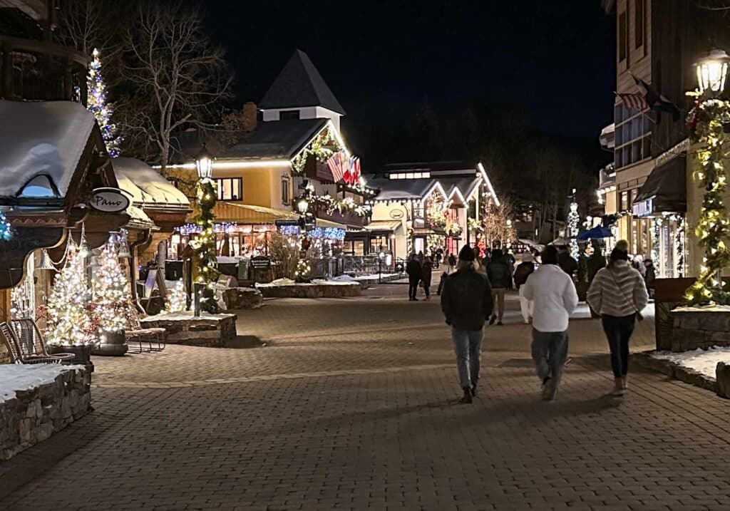 Vail Village, Colorado, illuminated at night with snow-covered streets and Alpine-style buildings.