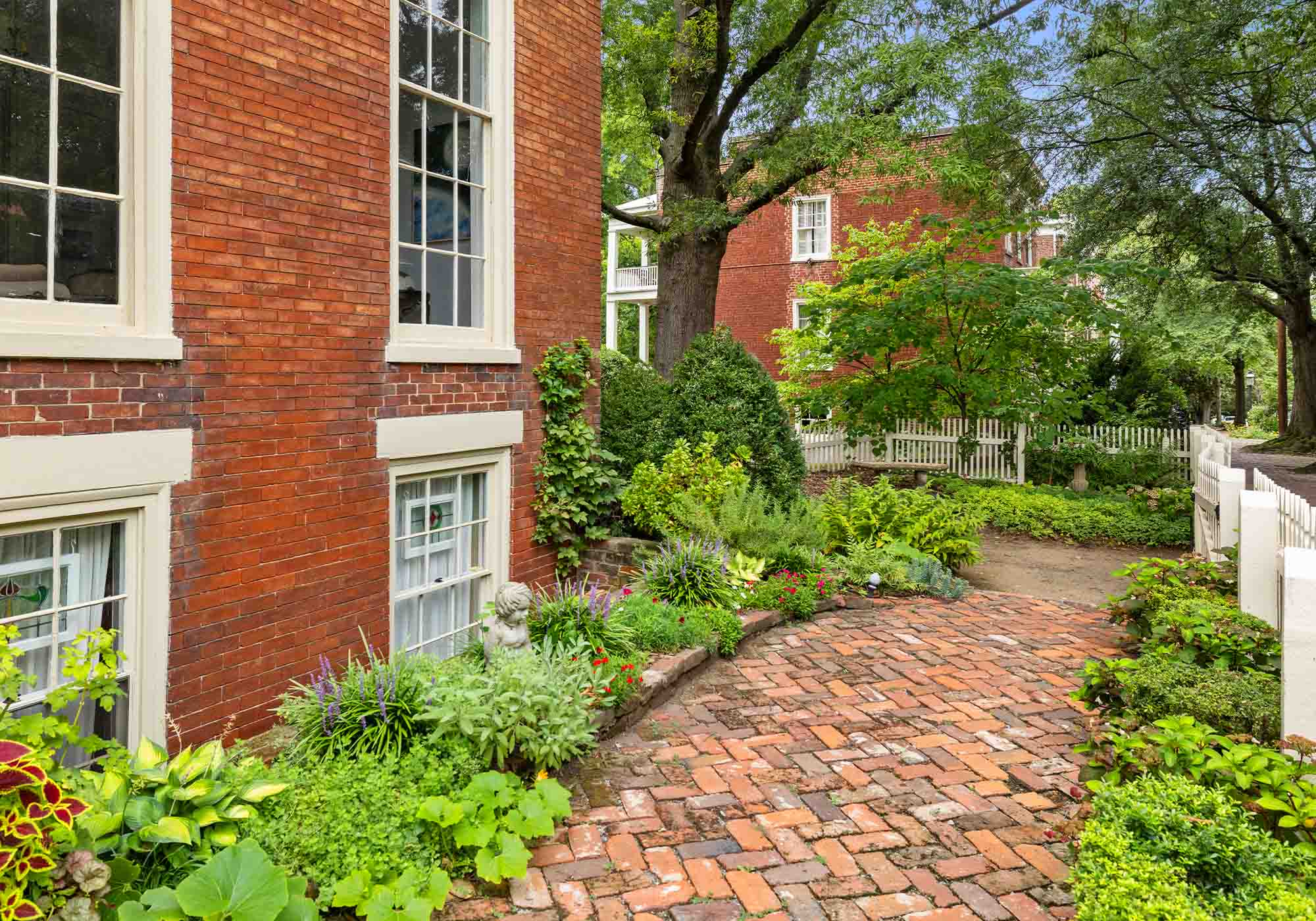 Brick courtyard lined with manicured shrubs in Church Hill, Richmond, part of Virginia’s Historic Garden Week 2026