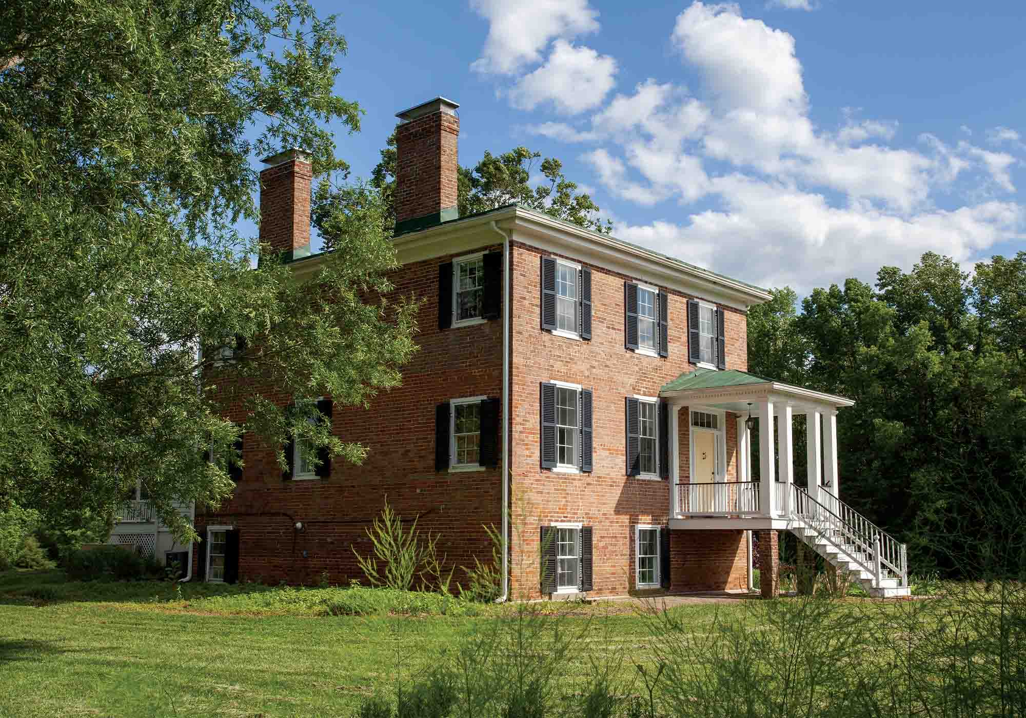 Historic Middle Peninsula Virginia home surrounded by trees in an open pastoral field during 2026 Historic Garden Week